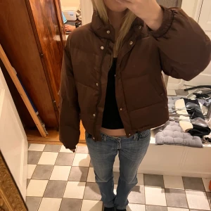 Champion Jacka - Så fin pufferjacka som inte kommer till användning! Brun och lite glansigt material:) obs två hål i fodret inuti som lätt går att sy ihop, skriv för bättre bilder på det vid intresse.