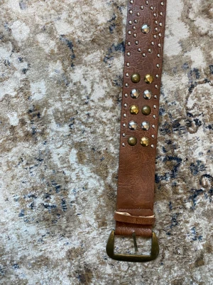 Coolt bälte med nitar - Lite tjockare bälte med nitar och coola detaljer. Tecken på användning men i bra skick.
