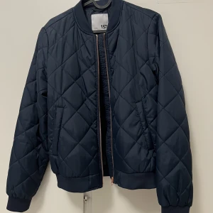 Bomberjacka  - Helt oanvänd bomberjacka i marine blå färg med rose gold dragkedja. 