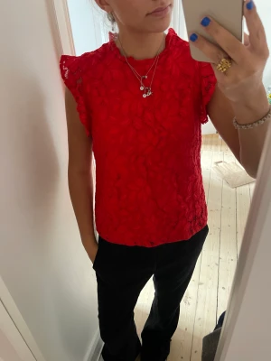 Röd topp  - Säljer denna supersnygga topp i röd och spetsliknande material, säljer pga att jag inte använder den så ofta! Skriv vid intresse💓tillkommer frakt!
