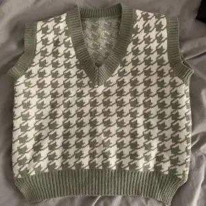 Green and white sweater vest. Perfect for spring. Works very well with a white shirt underneath!! Size S/M