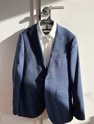 Kostym till student - Hel kostym med kavaj, byxor och skjorta av märket Riley säljes. Använd vid ett tillfälle. Som ny.