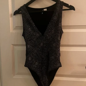 Nyårstopp - Glittrig body. Perfekt till nyår eller fest. Superfint skick. Man ser de fina mönstret bättre på andra bilden ✨