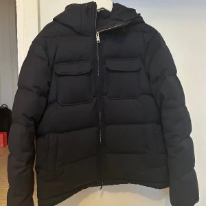 Emporio Armani Dunjacka  - Supersnygg dunjacka från Emporio Armani i superfint skick. Väldigt sparsamt använd. I marinblå färg.   Inköpt för ca 6700 sek.