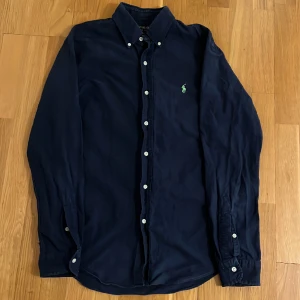 Ralph Lauren skjorta - Fin Ralph Lauren skjorta i en mörkblå färg, storlek M. Skjortan har inga deffekter, därför ett fint skick. Nypris 1400. Skriv för fler bilder eller om frågor finns. 