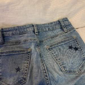 jättefina ljusblåa lågmidjade jeans med stjärnor på bakfickorna <3