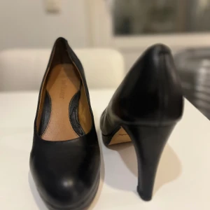 Svarta pumps Clarks nypris 1500 - UK 6. Storlek 39. Storleken stämmer. 1,5 cm platå. Klack 9 cm (7,5 utan platå). Mjuk kudde för trampdynan. Superbekväma.