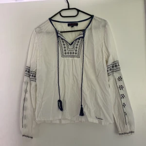 Blus Bondelid - Vit långärmad blus med mörkblåa detaljer från bondelid. Sparsamt använd, lite lösa trådar går lätt att klipp bort.