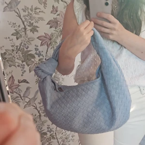 Ljusblå, vegansk Bottega Veneta-liknande handväska - Eftersom jag har använt den kanske en gång så säljer jag den till någon som den passar bättre.  Nästan oanvänd Mellanstor Flätad  Vegansk  Stängs med blixtlås Ett mindre fack med blixtlås innuti väskan.