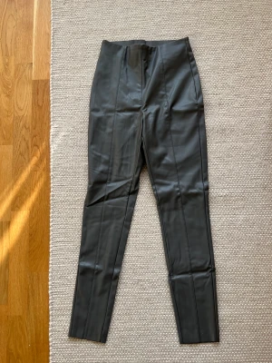 Helt oanvända gråa skinnbyxor - Helt oanvända gråa skinnbyxor med lappen kvar från hm. Storlek 38.