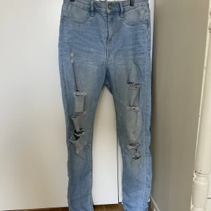 Ljusblåa ripped jeans HM - Ett par ljusblåa jeans från HM. Skinny med high Waist och är ”ripped” framtill. Mycket stretch. Använt ett fåtal ggr. Storlek 38.