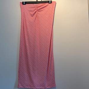 Ett jättefint rosamönstrat sett med långkjol och topp, kjolen har en liten ”skrunch” framtill och toppen har en snygg öppen rygg. Detta settet är väldigt stretchigt och tröjan knyter man själv så man kan välja hur stor man vill ha den nertill.