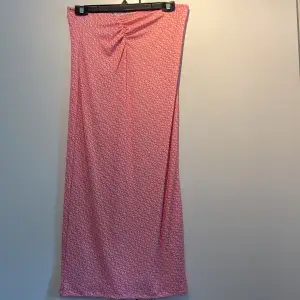 Ett jättefint rosamönstrat sett med långkjol och topp, kjolen har en liten ”skrunch” framtill och toppen har en snygg öppen rygg. Detta settet är väldigt stretchigt och tröjan knyter man själv så man kan välja hur stor man vill ha den nertill.
