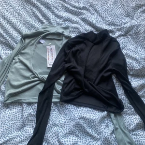 Rygglös top - Två stycken rygglösa toppar från new yorker. Den gröna är aldrig använd och den svarta är använd fåtal gånger men har blivit lite blå från en annan tröja. Säljs i par.  Storlek S men passar M   Nypris: 120kr/st