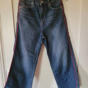Snygga mörkblåa jeans med röd detalj på sidorna. Innebenslängd är 61 cm. Bra skick🤩