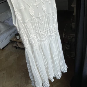Perfekt studentklänning - Fin vit midi klänning med brodyr och tull. Sitter tight upptill men faller efter höften. 