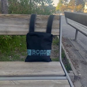 Hugo Boss väska  - Jag köpte denna väska från Hugo Boss hemsida 2021 för 1100, men vill nu sälja den eftersom den inte passar min still. Den här väskan är sällsynt och finns ingenstans att köpa längre eftersom den är med i kategorin av de gamla HugoBoss. (Ny skick)