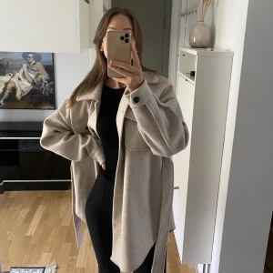 Höstjacka / Filtjacka  - Filtjacka med skärp i nyskick. Ljusbeige med svarta knappar, oversize modell stl: 34 (men passar XS/S)