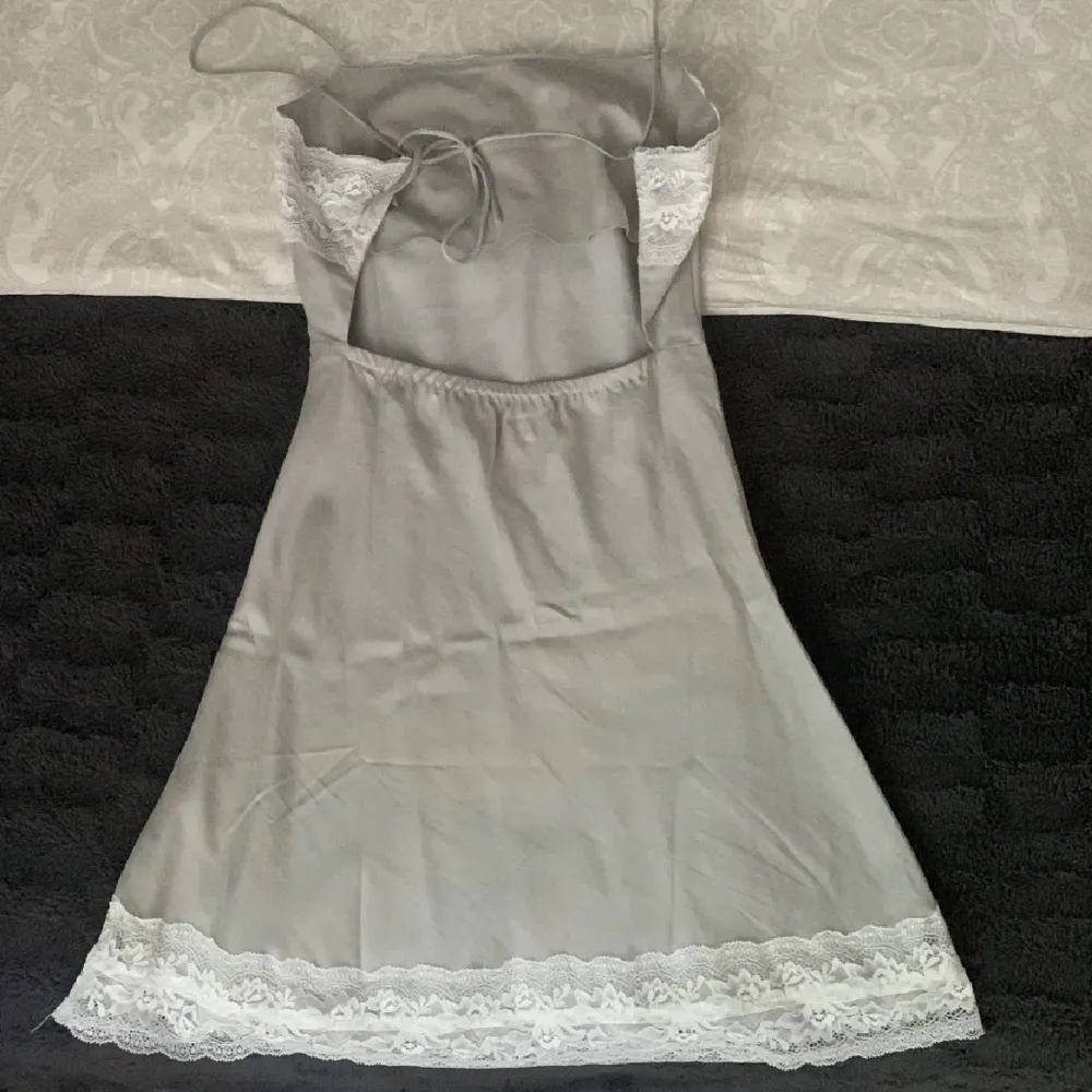Så vacker klänning i silkesliknande material. Ljusgrå med vit spets. ❤️ aldrig använd (lånade bilder). Finns ej kvar att köpa och nypris är 1499kr. Klänningar.