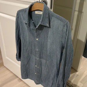 Skjorta med vändbar krage - Dockers skjorta med vändbar krage, finns 3 knappar inuti skjortan så önskar du att bära utan krage kan du vika in dom och knäppa kragen innanför skjortan. 100% Cotton 