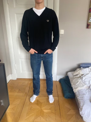 Fred Perry Tröja - En elegant tröja som var tillverkad i Storbritannien 🇬🇧 av Lammull som känns och är som marinoull. Tröjan har inga defekter och är som i nyskick och därför säljer jag den för bara 499kr kontra original priset som är 1299kr. 