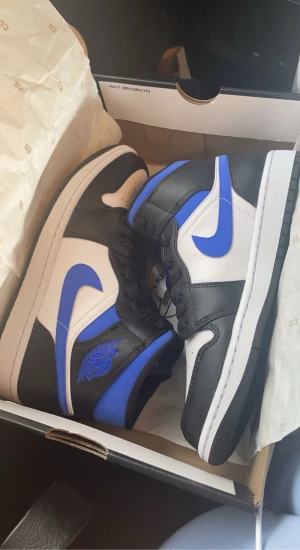 Jordans  - Air Jordan 1 Mid White Black Royal, kartong medföljer, inte använda mycket, köpte de för 2799kr i Göteborg på kicksnstuffse. Inga defekter förutom lite krisade på ena skon (se bild) passar även folk med storlek 39 ( små i storleken)