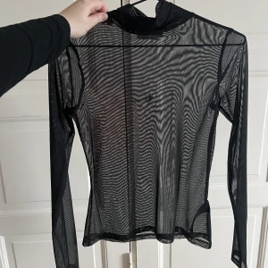 Svart Meshtröja med polo  - Svart meshtröja från NAKD med polokrage. Aldrig använd!  