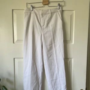 Kostymbyxor - Jättesnygga kostymbyxor från Gina Tricot, regular waist. Suttit jättesnyggt baggy på mig som är 32/liten 34. Uppsydda för hand med diskreta stygn som lätt går att sprätta upp om man vill ha full längd. Endast använda 1 gång.
