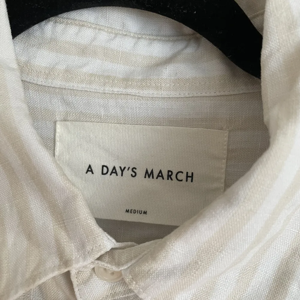 Säljer en vit/beige randig skjorta från märket A Day’s March i storlek Medium.  Köpt ny för cirka 1200kr. Skjortor.