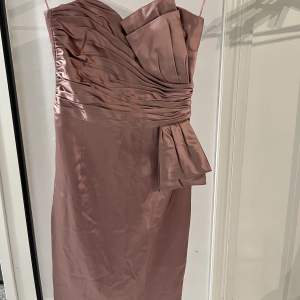 Detta är en balliknande klänning köpt från Belle by OASIS för flera år sedan. Den har en jättefin rosa färg med fina detaljer som är perfekt att ha till bal eller bröllop. Den är shoulderless och kroppsformad