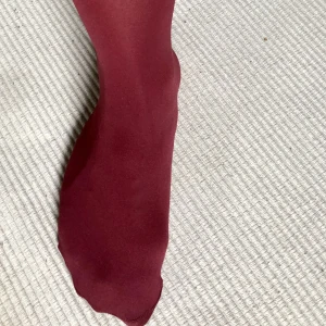 Strumpbyxor - Tjockare nylonstrumpbyxor i en vinröd nyans. Endast använda en gång. Nyskick.