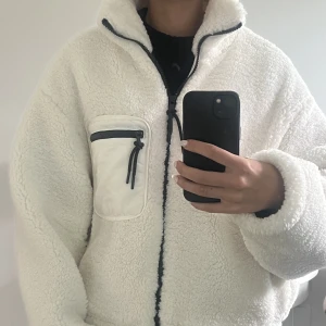 jacka från NA-KD - en teddyjacka som är kort i modellen och med hög krage, i storlek xs. Köptes i början på året och är en perfekt höst jacka, inte kommit till användning så i ett mycket bra skick🥰