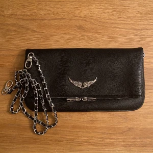Zadig & Voltaire Väska - En jättefin Zadig & Voltaire väska. Dustbag och kedjor i två längder medföljer. Kund står för frakt. Priset är inte hugget i sten och kan förhandlas! Kan leverera i Uppsala eller frakta.