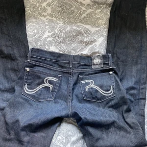 Lågmidgade jeans -  Säljer dessa tvärkattiga mörkblå jeans, det har låg midja och har raka ben