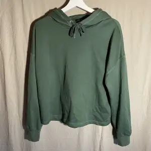 En grön tröja med luva från amisu. Det är storlek M. Den är lite åt det tunnare hållet. Använd endast fåtal gånger, den är i bra skick och har inga slitskador😁 hör av dig vid fler frågor!