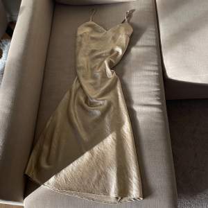 Silke klänning i ”guld” super fin och tjockt material ser dyr ut. Gå att justera band. Längd 95cm. 