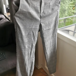 Rutiga kostymbyxor.  - Bra skick, kan förekomma katthår. Midja: 36 cm, insida ben: 72 cm, gren fram: 24 cm. 