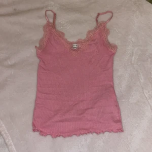 Linne - Jätte gulligt rosa linne som inte kommer till användning. Bra skick och knappt använd. Linnet är ribbad men spets på övre och justerbara band.Skriv vid frågor.