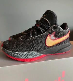 Lebron 20 Trinity - Basketskor i fint skick som är knappt använda i storlek 38,5  Information från Nikes hemsida  De har Zoom Air-dämpning och en extra lätt känsla så att du kan springa, hoppa och skjuta fram till slutsignalen. Finns i röd- och djurfritt hem. Nypris