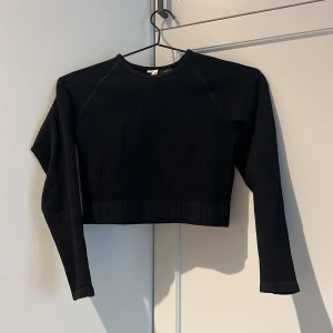 Tight träningstopp Nelly.com - Svart croppad tight träningstopp från nelly trend. Använd 2 ggr, som ny!