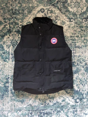 Canada goose väst - Asbekväm canada goose väst, perfekt till kallare sommarkvällar samt höst och vår. Storlek på lappen XS men sitter mer som M/L köpt på vestiare, knappt använd väldigt bra skick
