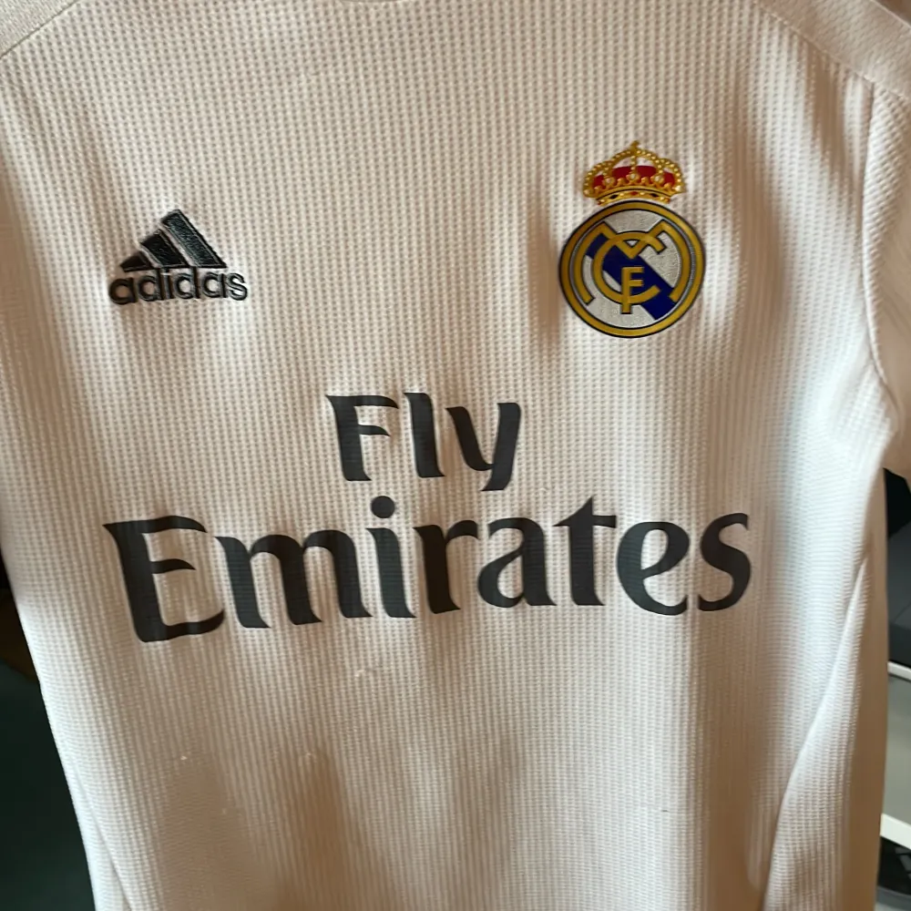 Säljer denna Real Madrid tishan för att den är för liten. Storleken är lite oklar men skulle säga att det är xs. På andra bilden står det lite olika storlekar. Skriv om du har några frågor. . T-shirts.