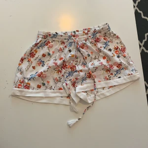 Vita shorts med blommor. - Vita shorts med blommor.
