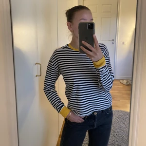 Tröja - En söt svart- och vitrandig tröja med gula muddar