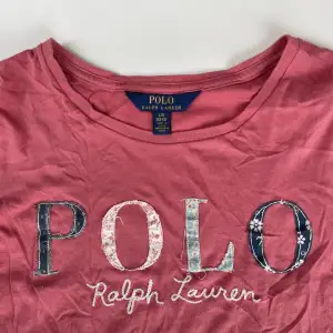 Jättefin rosa Ralph lauren t-shirt som tyvärr blivit för liten för mig. Passar jättebra till blåa jeans🩵💙litet hål på baksidan men märks knappt och kan säkert sys ihop. Nypris: ca 600kr Strl 12-14, passar xs
