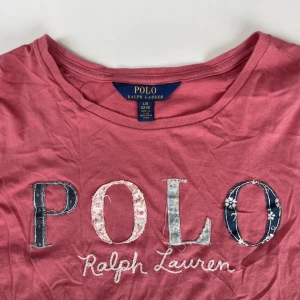 Ralph Lauren t-shirt  - Jättefin rosa Ralph lauren t-shirt som tyvärr blivit för liten för mig. Passar jättebra till blåa jeans🩵💙litet hål på baksidan men märks knappt och kan säkert sys ihop. Nypris: ca 600kr Strl 12-14, passar xs