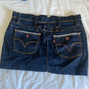 Lågmidjad jeanskjol  - En lågmidjad kort jeanskjol från Levis. Säljer då jag tycker den är lite för tajt på mig. Det är en knapp som saknas men det är enkelt att fixa. Skulle passa storlek S ungefär. Utöver knappen så är den i bra skick.