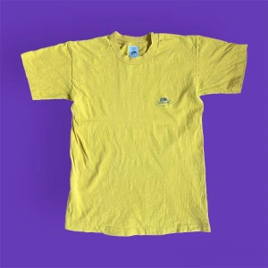 Vintage Gul Fruit Of The Loom T-shirt - Fin vintage t-shirt från märket ”Fruit of The Loom”, från tidigt 2000-tal i USA. I helt okej skick, lite nopprig samt ett liten hål i ena armhålan, går dock att enkelt sy ihop! Små fläckar som knappt syns. För fler bilder eller mått kontakta mig 💫 