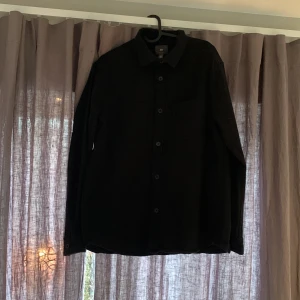 Overshirt - Hej, Säljer nu min svarta Overshirt från hm som bara andvänts ett fåtal antal gånger och är i ett väldigt bra skick. Passar riktigt bra till sommaren med en basic vit t-shirt under. Säljs pågrund av att den är för liten för mig. Skriv för fler funderingar