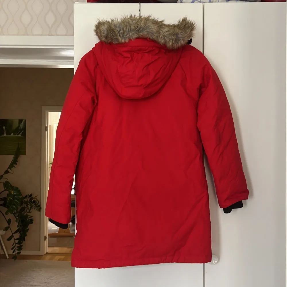 Snygg & varm ny röd Everest vinter jacka.  Har en ficka på insidan samt fyra fickor på utsidan & luva med päls.  Finns både dragkedja & knappar. Storlek 34.. Jackor.